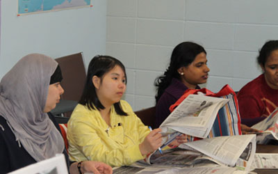 adult students looking at newspapers