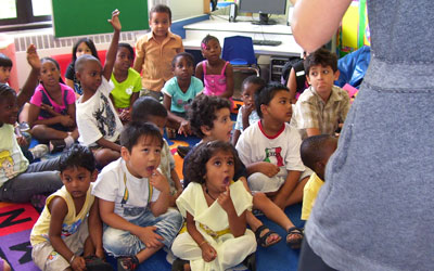 a group of children listening to a teacher