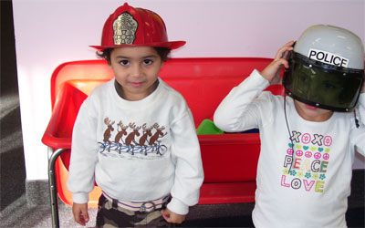 children in police and firemen hats