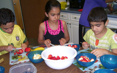 children preparing a fruit snack
