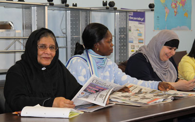 adult students looking at newspapers